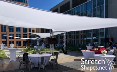 White stretch sails providing shade and ceiling dÃ©cor for live event