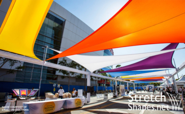 Different colors of spandex sails stretched out over walkway