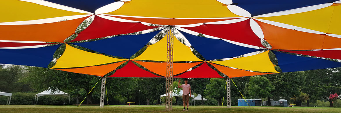 Yellow Red And Blue Triangle Stretch Fabric Sails Connected To Make A Shade Structure