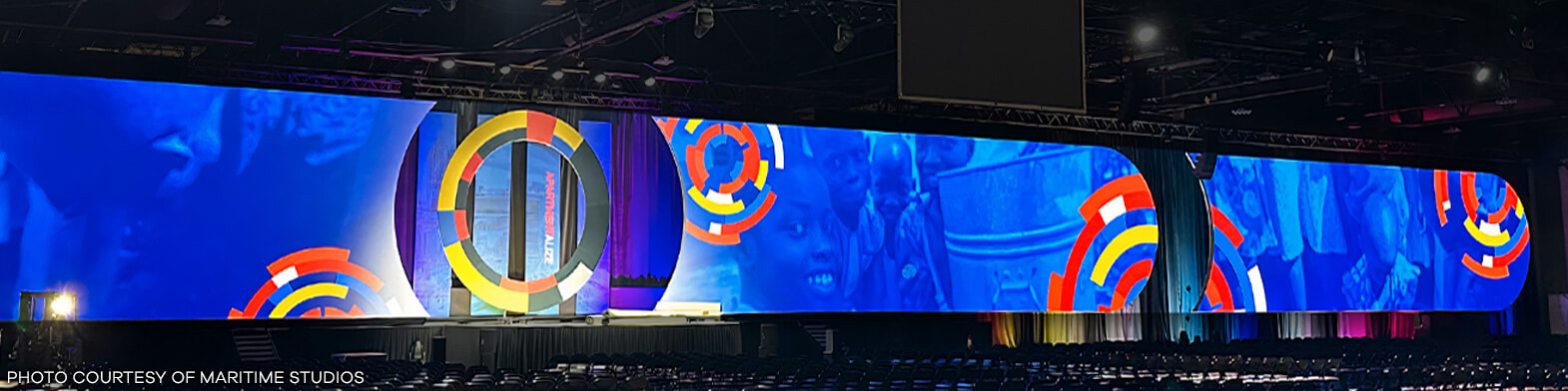 A large and colorful borderless projection screen on stage